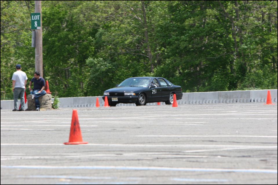 Black sedan with number 251 on door, navigating an autocross course with orange cones