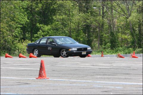 2001 Mercury Grand Marquis - A black sedan, marked with the number 251, maneuvers through an autocross course marked by orange traffic cones.