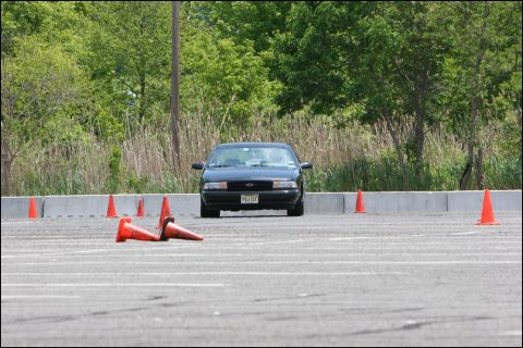 2001 Mercury Grand Marquis - A black sedan navigates an autocross course marked by orange cones. The license plate is visible.