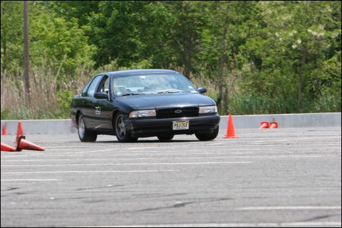 2001 Mercury Grand Marquis - Black sedan navigates an autocross course marked by orange cones.