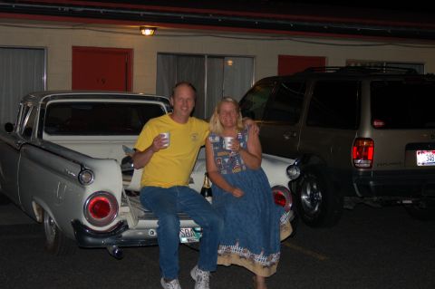 1967 Ford Ranchero - A couple enjoys drinks while sitting on the back of a classic pickup truck.