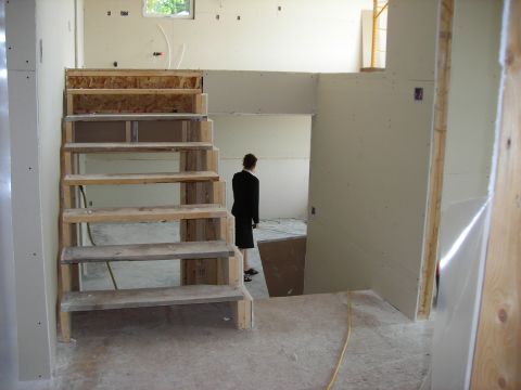 1984 Ford Bronco - A construction site interior shows an unfinished staircase and a person in a suit observing the space.
