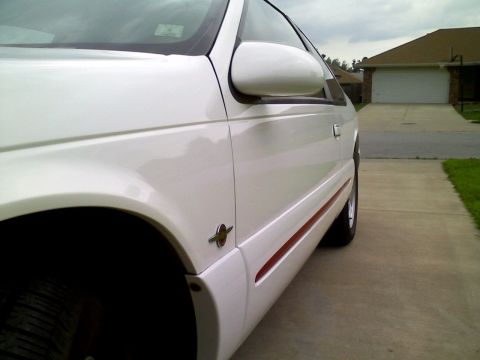 1995 Ford Thunderbird - A white 1995 Ford Thunderbird coupe is parked on a driveway, with a garage in the background.