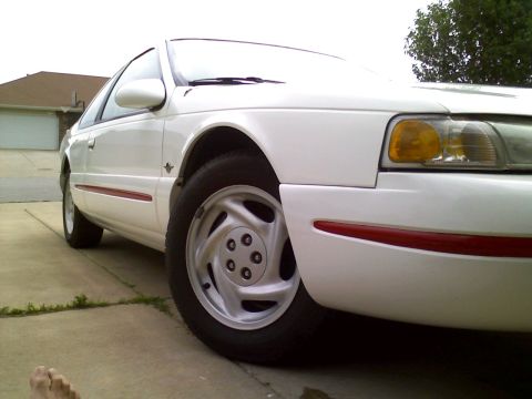 1995 Ford Thunderbird - The front passenger side of a white 1995 Ford Thunderbird is shown in a driveway.