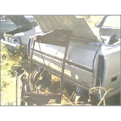 1973 Ford Ranchero - A collection of car parts in a junkyard, with a watermark at the bottom right.