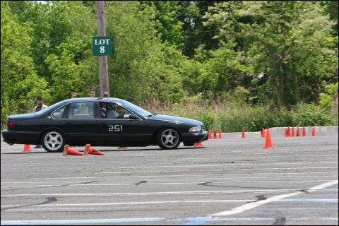2001 Mercury Grand Marquis - A black sedan navigates a course marked by orange cones on a sunny day.
