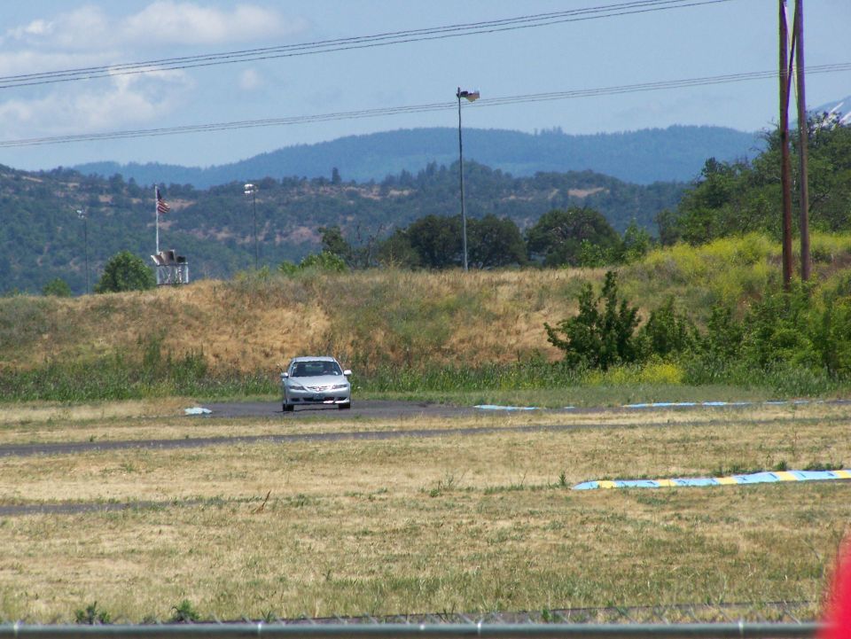 Silver 2007 Mazda 3 sedan on a track, front view