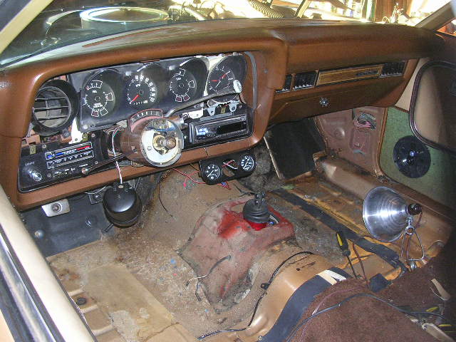 1975 Ford Ranchero interior with brown dashboard, aftermarket radio, and floor shifter