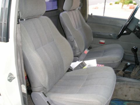 1986 Toyota Hilux - The interior of a truck features gray fabric seats and a manual transmission shifter.