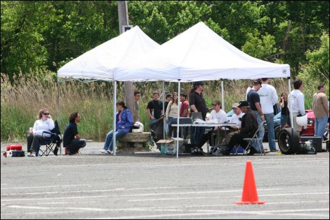 2001 Mercury Grand Marquis - An outdoor event with people gathered under tents, with a traffic cone visible on the asphalt.