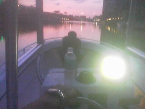 1989 Ford Bronco - The interior of a boat is seen at dusk with a calm body of water in the background.