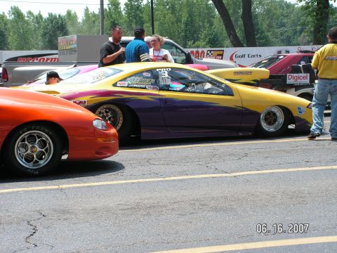1988 Ford Mustang - A colorful drag car sits on the track, with other vehicles and spectators in the background. The date 06.16.2007 is visible.