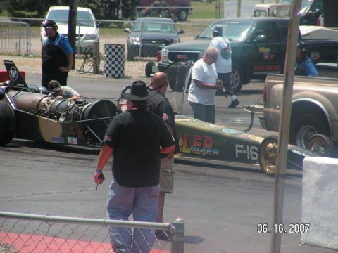 1988 Ford Mustang - A jet dragster with F-16 and Viper graphics sits on the track, with crew members around it.