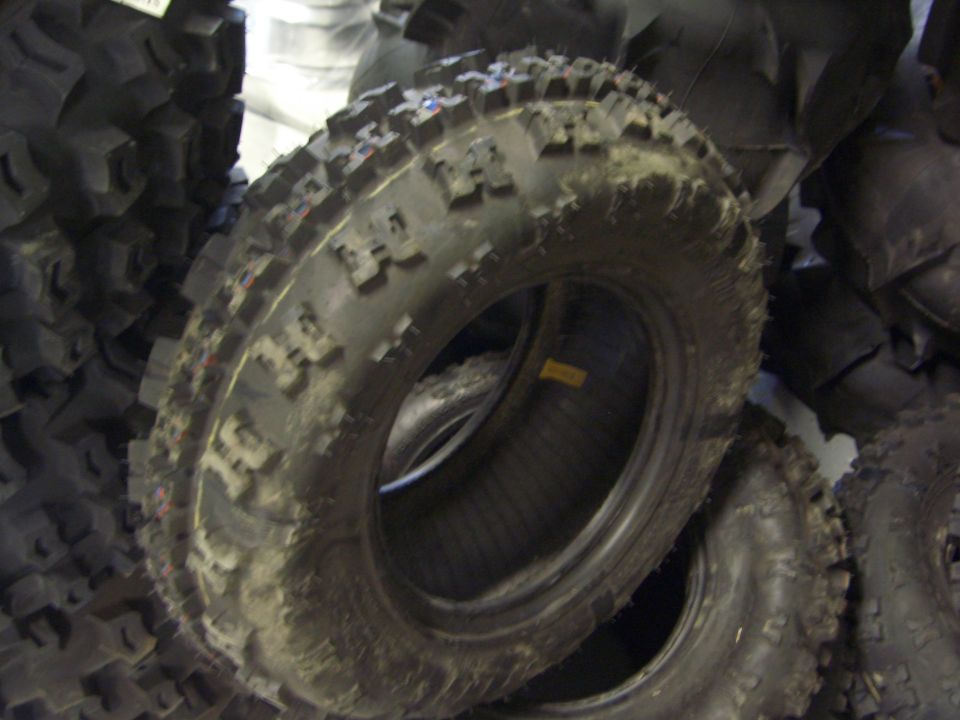 Pile of knobby off-road tires, one in foreground is dirty