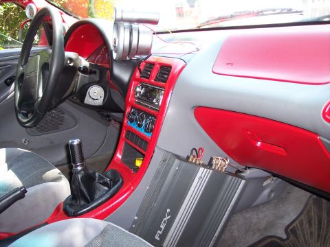 1994 Ford Probe - Interior of a 1994 Ford Probe, custom red trim and an aftermarket amplifier.