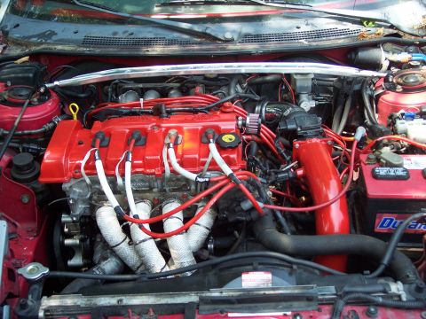 1994 Ford Probe - Close-up view of a modified car engine bay, red painted components and aftermarket intake.