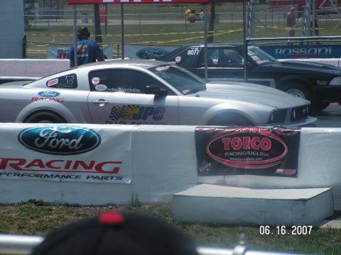 1988 Ford Mustang - A silver Ford Mustang is lined up on a drag strip, with a black Ford Mustang in the adjacent lane.