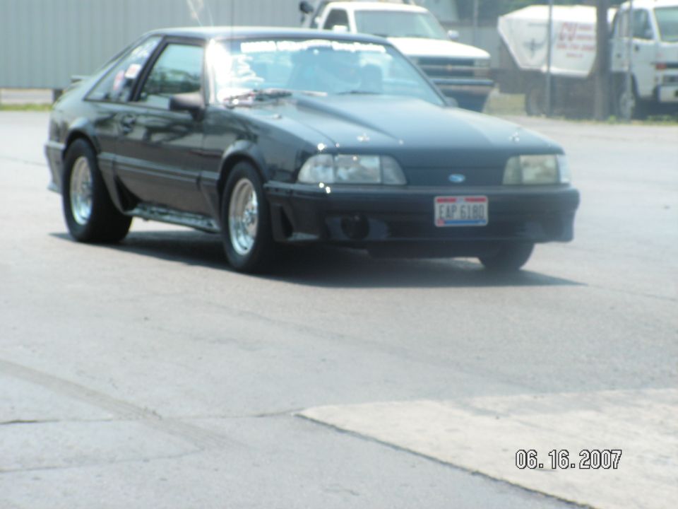 Black Fox-body Ford Mustang hatchback, front three-quarter view, polished wheels and hood scoop, Ohio plate EAP 6180