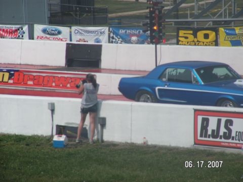 1988 Ford Mustang - A blue 1967 Ford Mustang coupe is seen on a drag strip with a photographer in the foreground.