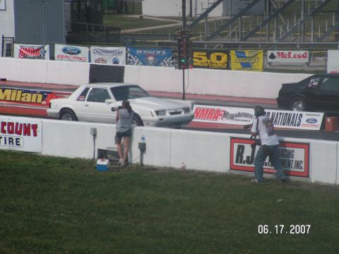 1988 Ford Mustang - A white 1988 Ford Mustang is positioned on the drag strip, with a second vehicle visible to its right.
