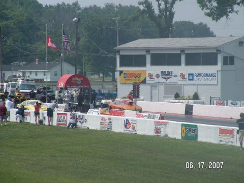 1988 Ford Mustang - Drag racing event at Milan Dragway, multiple vehicles and spectators on a sunny day.