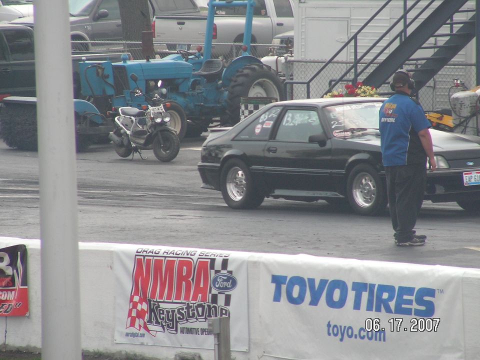 Black Fox-body Ford Mustang hatchback in the pits at an NMRA drag racing event