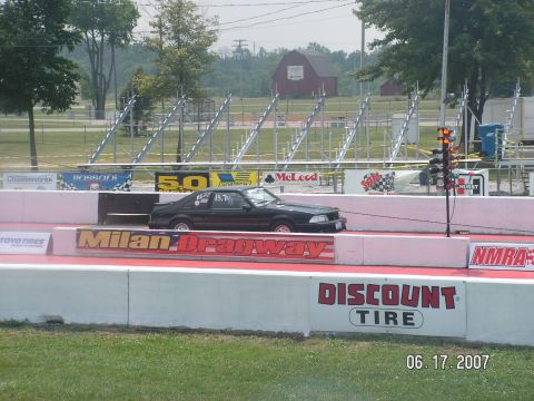 1988 Ford Mustang - A black 1988 Ford Mustang is captured in profile on the drag strip at Milan Dragway.