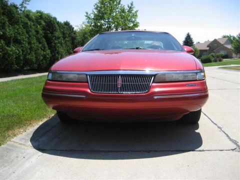 1996 Lincoln Mark VIII - The front grille and headlights of a red 1996 Lincoln Mark VIII are visible.