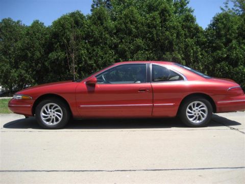 1996 Lincoln Mark VIII - Side view of a red coupe with a distinctive body style, possibly from the early to mid-1990s.