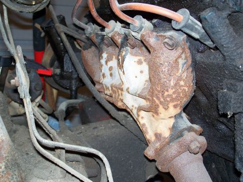 1979 Ford F-150 - Close-up of a heavily rusted exhaust manifold and associated spark plug wires, likely from an older vehicle.