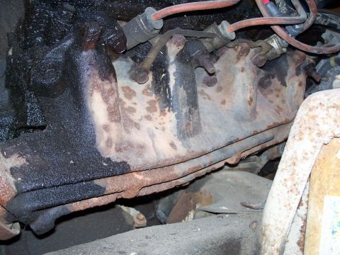1979 Ford F-150 - Exhaust manifold showing signs of rust and oil leakage.