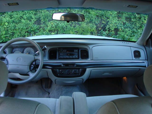 Tan interior dashboard of a Mercury sedan viewed from the rear seat