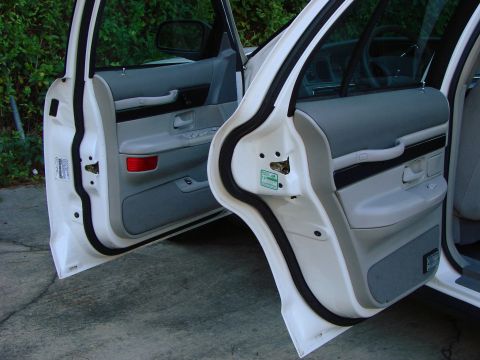1997 Mercury Grand Marquis - Interior view of the front and rear doors of a white sedan, revealing the gray door panels and trim details.