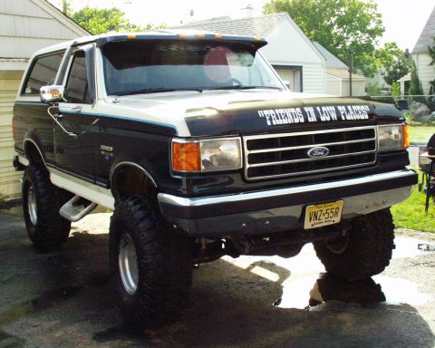 1989 Ford Bronco - This lifted 1989 Ford Bronco has a custom decal on its hood and is parked outdoors.