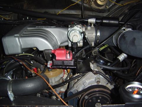 1986 Ford Bronco - Close-up view of an engine bay a silver intake manifold and a red ignition coil. The Supermotors.net watermark is present.