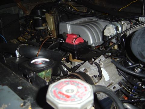 1986 Ford Bronco - Close-up of an engine bay showing an aftermarket intake manifold and ignition coil assembly.