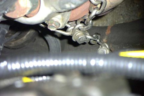 1997 Ford Taurus - Detail of engine components, including an exhaust pipe and a chain, with visible text from Supermotors.net.