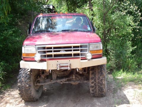1995 Ford Bronco - This red 1995 Ford Bronco is equipped for off-road adventures with large tires and a modified bumper.