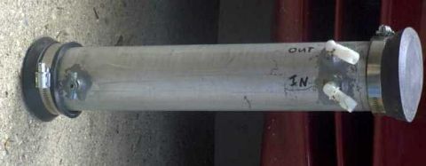 1997 Ford Taurus - Homemade oil catch can built from a clear plastic tube with rubber end caps and worm-gear hose clamps, laid on concrete. Two white barbed h…