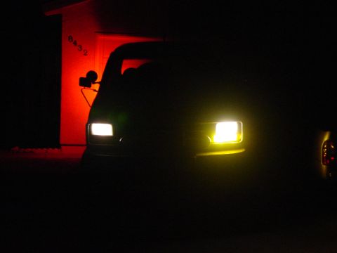 1994 Ford Bronco - A 1992 Ford Bronco is seen at night with its fog lights illuminated, parked in front of a building with red lighting.