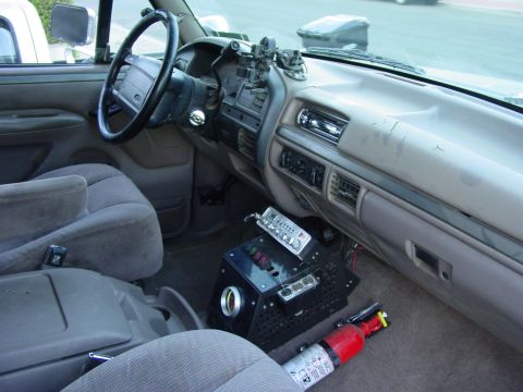 1994 Ford Bronco - The interior of the vehicle shows a dashboard with aftermarket equipment and a fire extinguisher.
