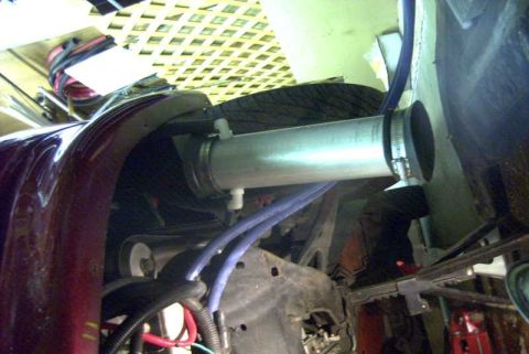 1997 Ford Taurus - Homemade PCV catch can built from an aluminum tube, mounted horizontally across the engine bay of a dark red car with black rubber end caps…