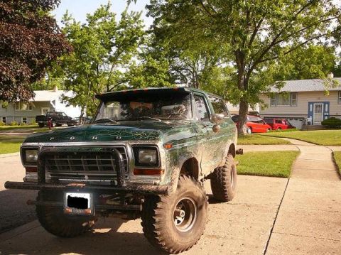 1978 Ford Bronco - This lifted 1978 Ford Bronco is covered in mud, suggesting recent off-road use.