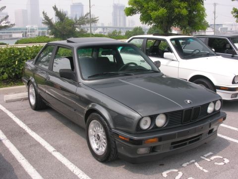 1989 BMW 3 Series - A dark gray 1989 BMW 3 Series coupe is parked in a lot with another BMW visible.