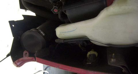 1997 Ford Taurus - This image shows a close-up view of engine bay components, including a fluid reservoir and various hoses.