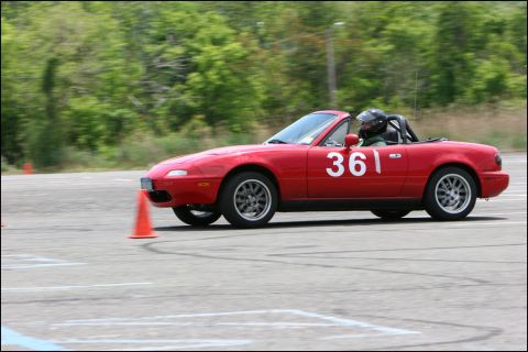 2001 Mercury Grand Marquis - A red Mazda Miata navigates an autocross course with a driver wearing a helmet.
