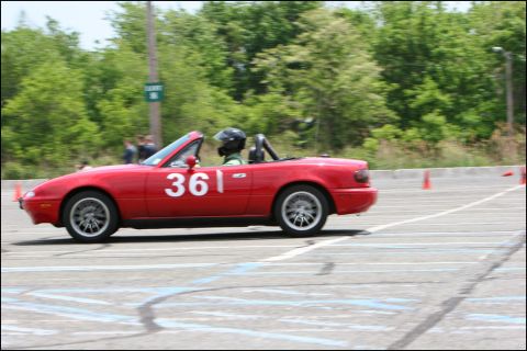 2001 Mercury Grand Marquis - A red convertible sports car with racing number 361 navigates a course marked by orange cones.