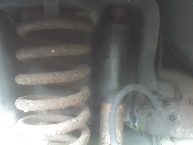 Rusty coil spring and shock absorber in a vehicle suspension