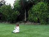 1991 Ford Bronco - A young child sits on the grass in a park-like setting, surrounded by lush green trees and foliage.