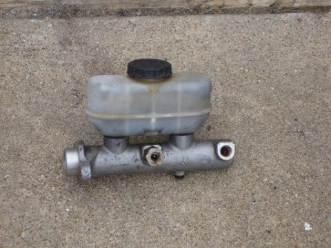 1996 Ford F-150 - Master cylinder part, likely for a vehicle, shown on a concrete surface. Text from SuperMotors.net is visible.